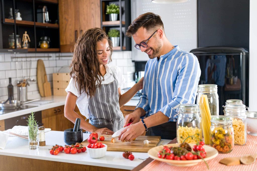 Happy,multiethnic,couple,cooking,homemade,tomato,and,basil,pasta.,cooking